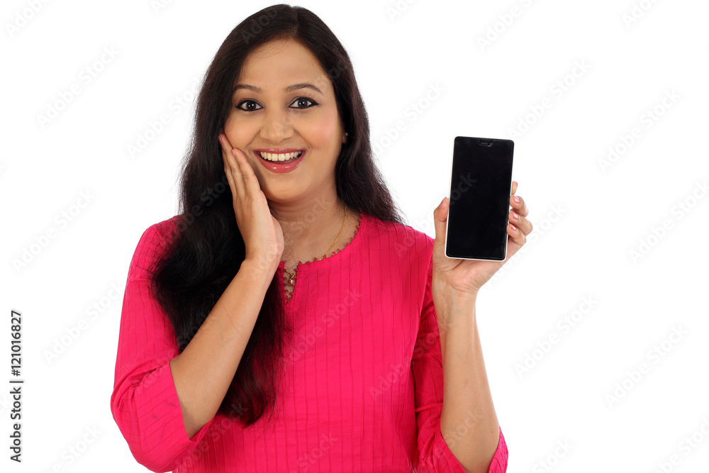 Happy young woman holding mobile photne against whtie background Happy young woman holding mobile photne against whtie background