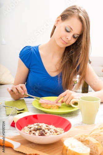 A young adult woman preparing a european style breakfast..