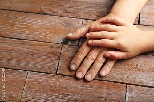 Hands of young child and old senior