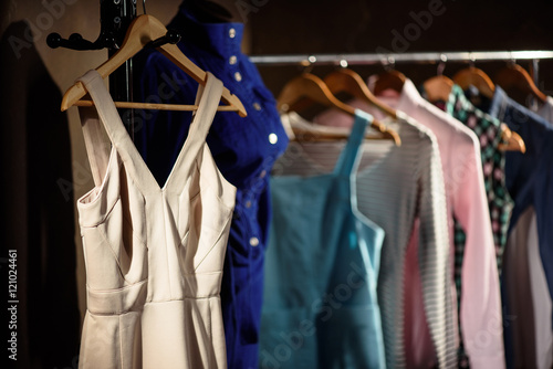 Stylish dresses on stand in wardrobe © Yakobchuk Olena