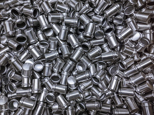 Shiny cold deformated cylindrical steel parts flat background photo