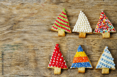 colored Christmas tree cookies on a dark wood background