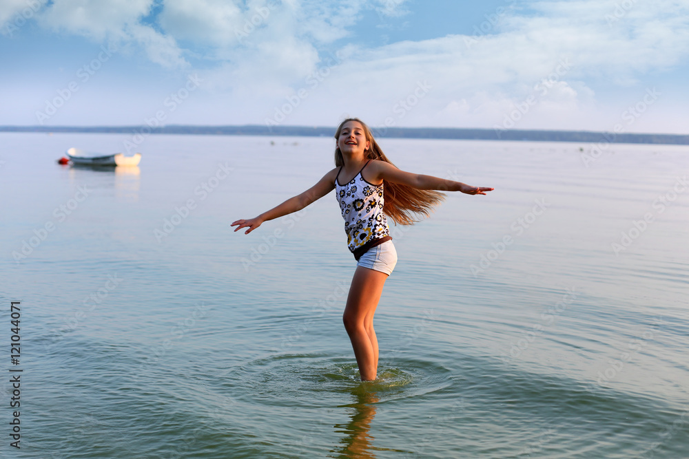 Piękna dziewczynka tańczy w wodzie jeziora. - obrazy, fototapety, plakaty 