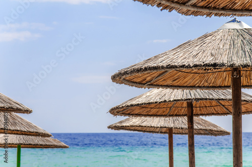 Fototapeta Naklejka Na Ścianę i Meble -  Straw umbrella on beautiful beach background close