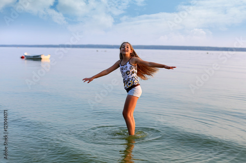 Piękna dziewczynka tańczy w wodzie jeziora.