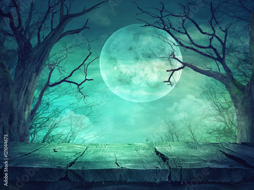 Spooky forest with full moon and wooden table