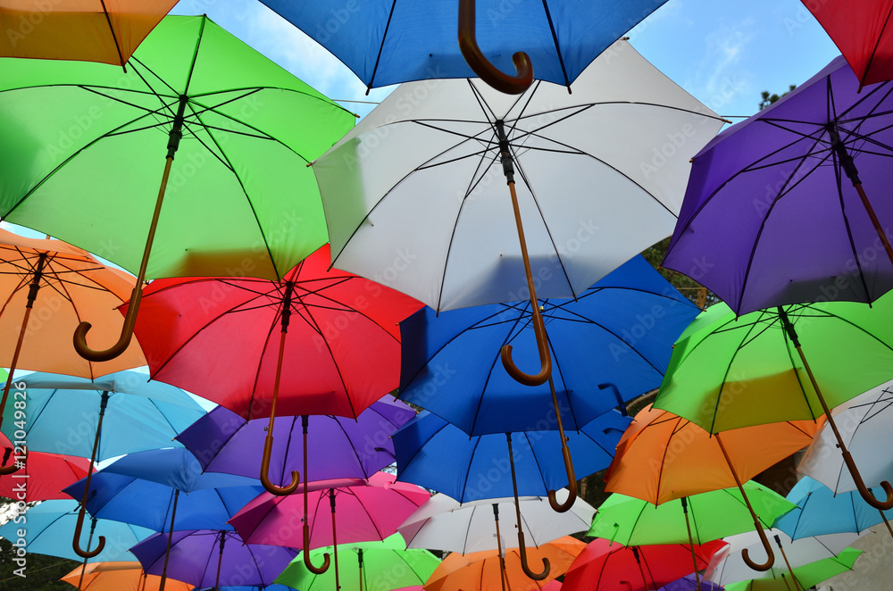 Colorful umbrellas with a part of blue sky with clouds