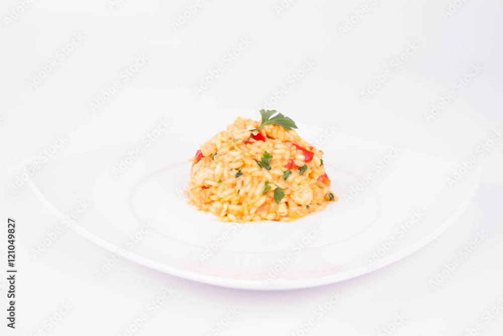 Risotto with chicken, tomatoes, bell pepper, onion and garlic on a white plate decorated with parsley Risotto with chicken, tomatoes, bell pepper, onion and garlic on a white plate decorated with parsley