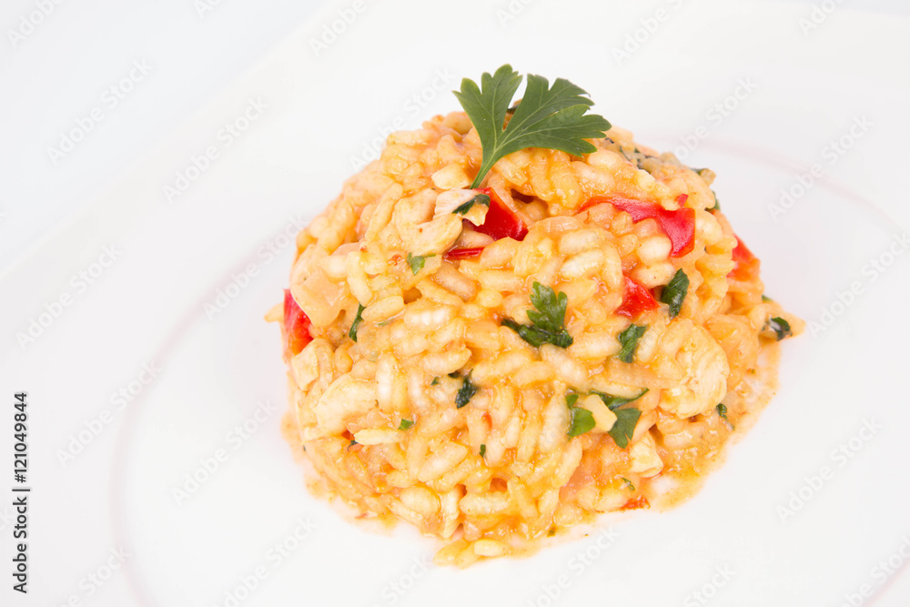 Risotto with chicken, tomatoes, bell pepper, onion and garlic on a white plate decorated with parsley Risotto with chicken, tomatoes, bell pepper, onion and garlic on a white plate decorated with parsley
