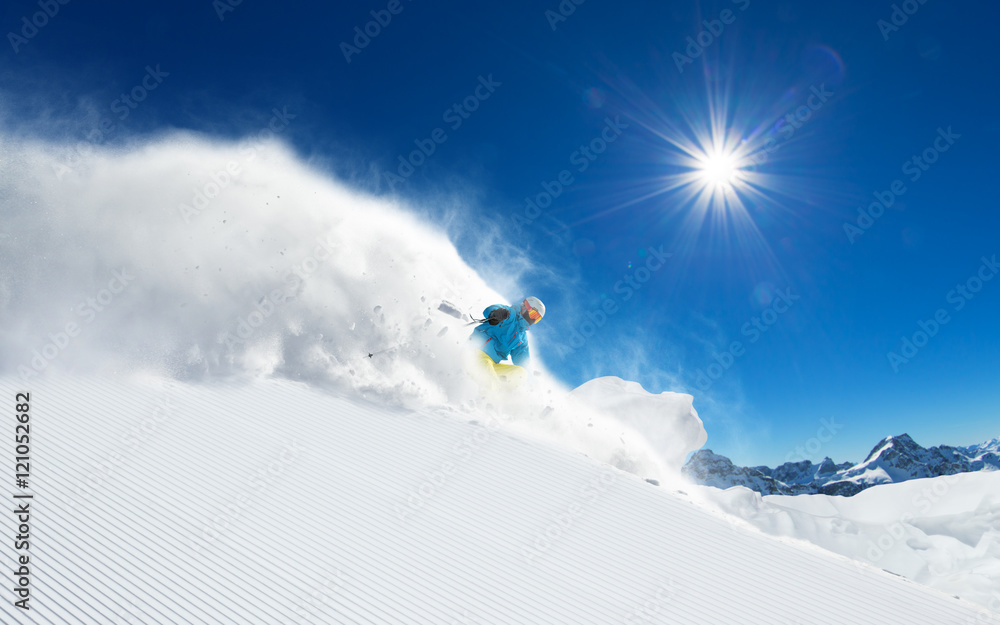 Skier skiing downhill in high mountains Skier skiing downhill in high mountains