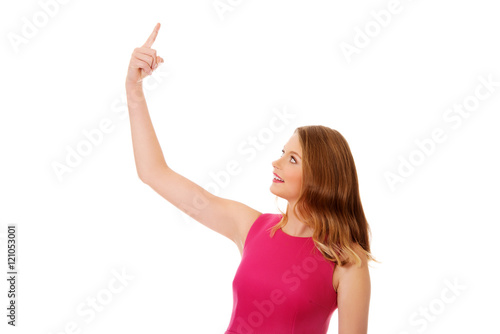 Young blonde woman pointing up