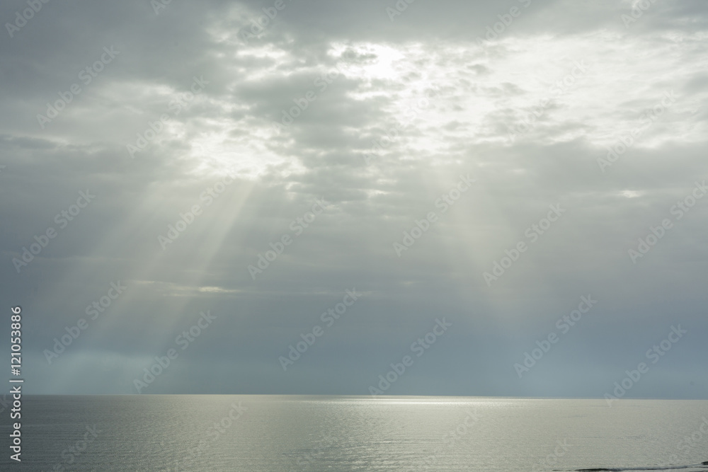 Ray of sun through the clouds lighting the horizon line between