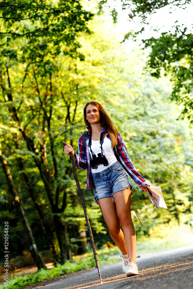 Young female with map hiking trough forest on beautiful summer day. Young female with map hiking trough forest on beautiful summer day.