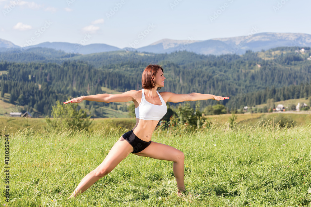 Fototapeta premium woman practices yoga in the mountains