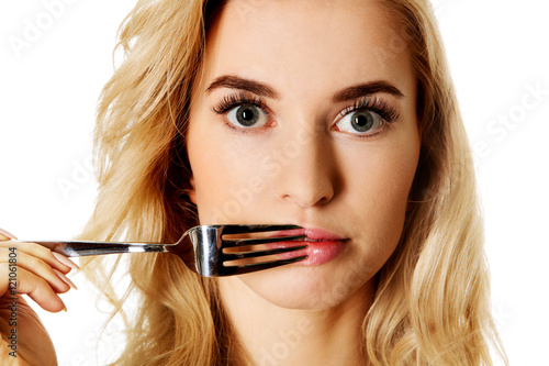 Woman touching her lips with fork photo