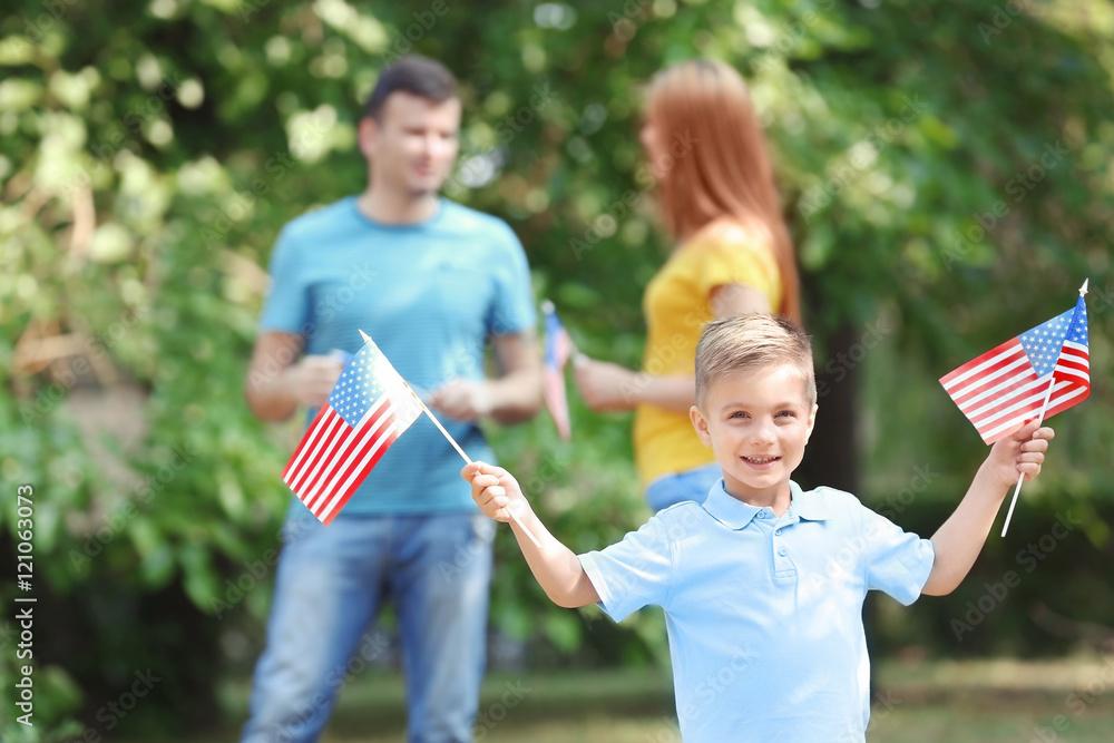 Happy family with American flags in park