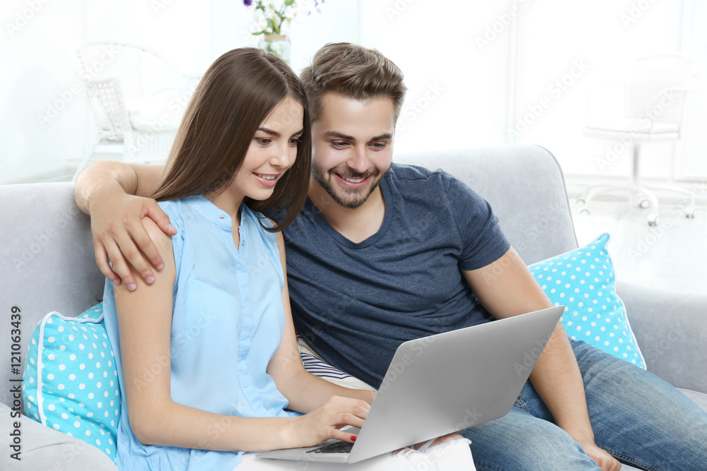 Beautiful young couple using laptop at home Beautiful young couple using laptop at home