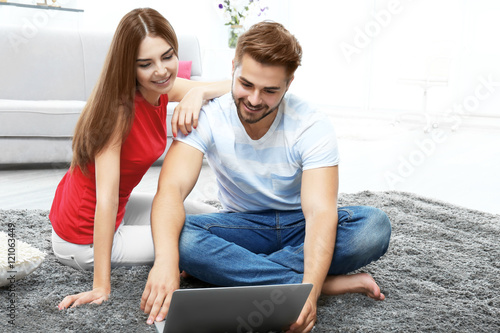 Beautiful young couple usin...