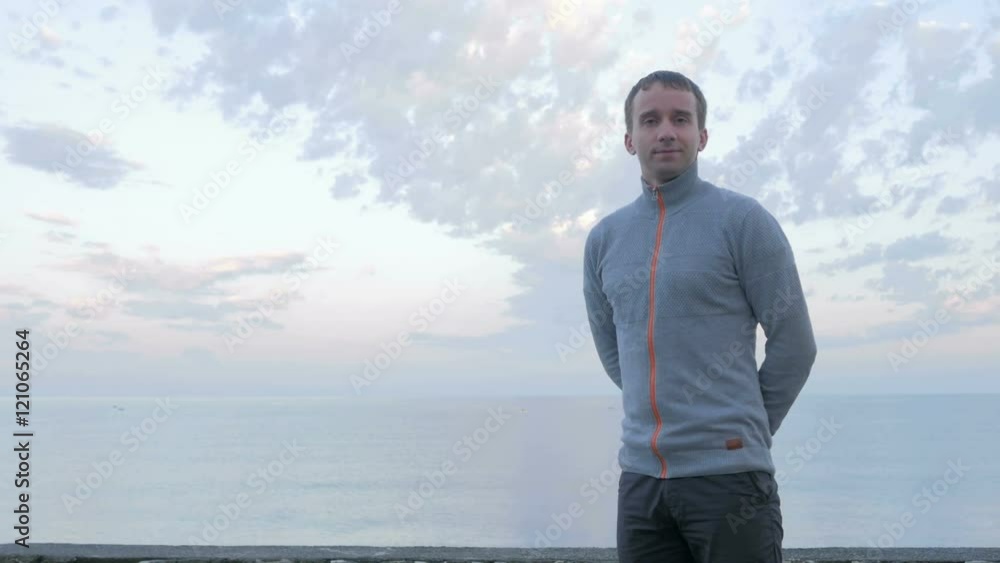 Handsome man in the early morning on the beach looking into the camera and smiling. Handsome man in the early morning on the beach looking into the camera and smiling.