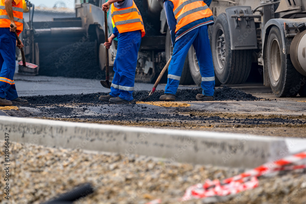 The workers and the asphalting machines The workers and the asphalting machines