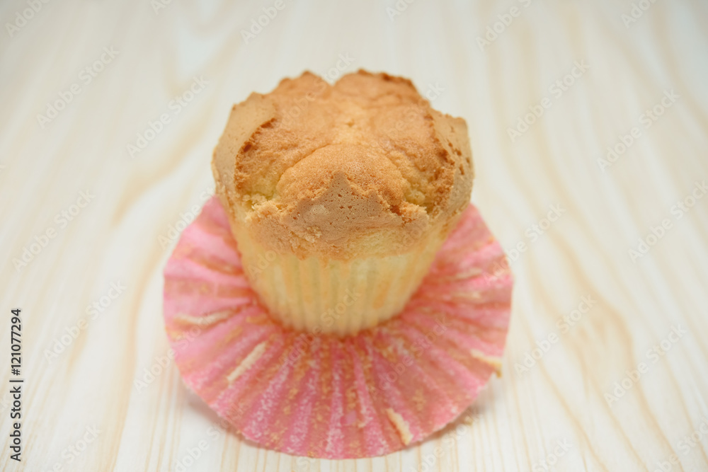 homemade cup cake with the outer opened on a wood background homemade cup cake with the outer opened on a wood background