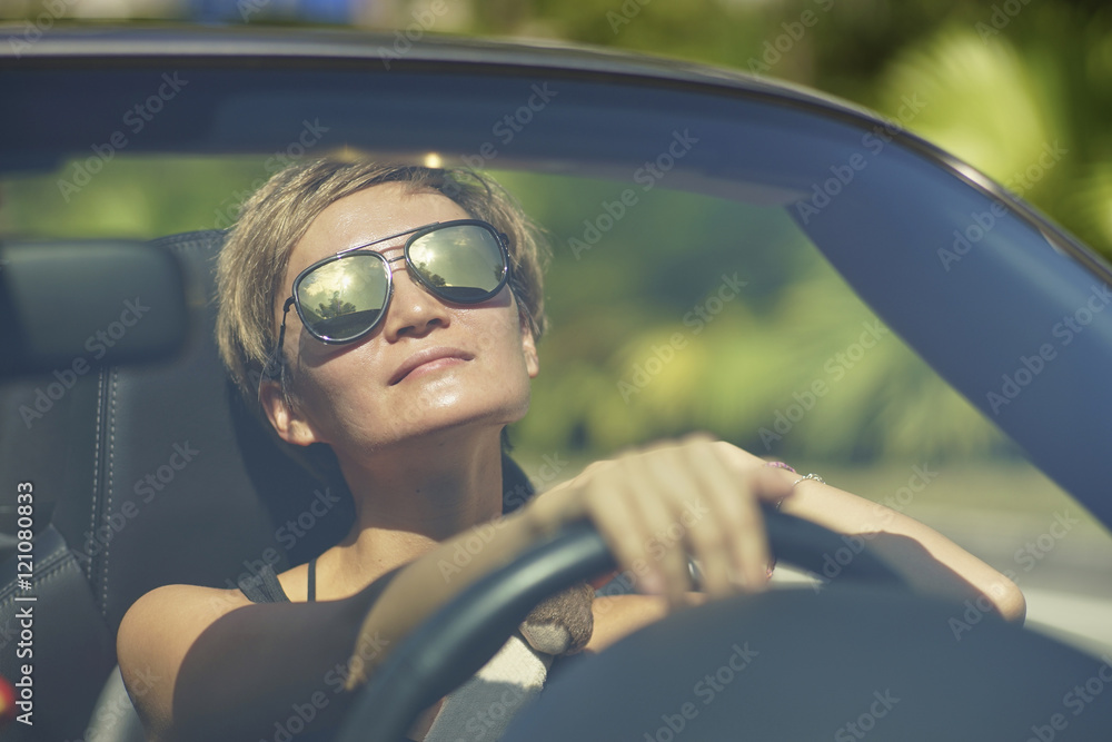 young asian woman driving a convertible car enjoying sunshine young asian woman driving a convertible car enjoying sunshine
