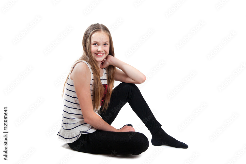 A smiling girl is sitting on floor, isolated on white background A smiling girl is sitting on floor, isolated on white background