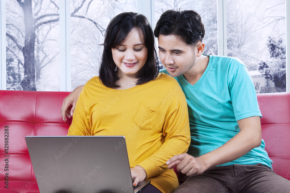 Fototapeta premium Couple using laptop in winter season