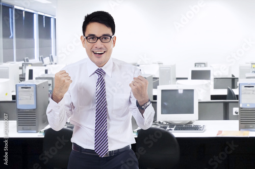 Man celebrating his success in office room