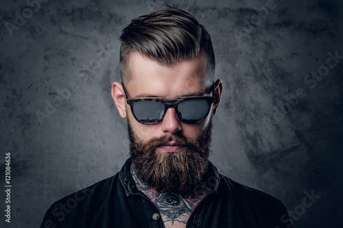 Tattooed, bearded male in sunglasses.
