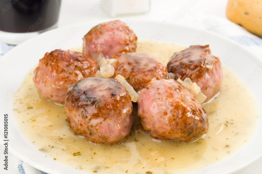 serving of cooked meatballs in sauce, on dish serving of cooked meatballs in sauce, on dish