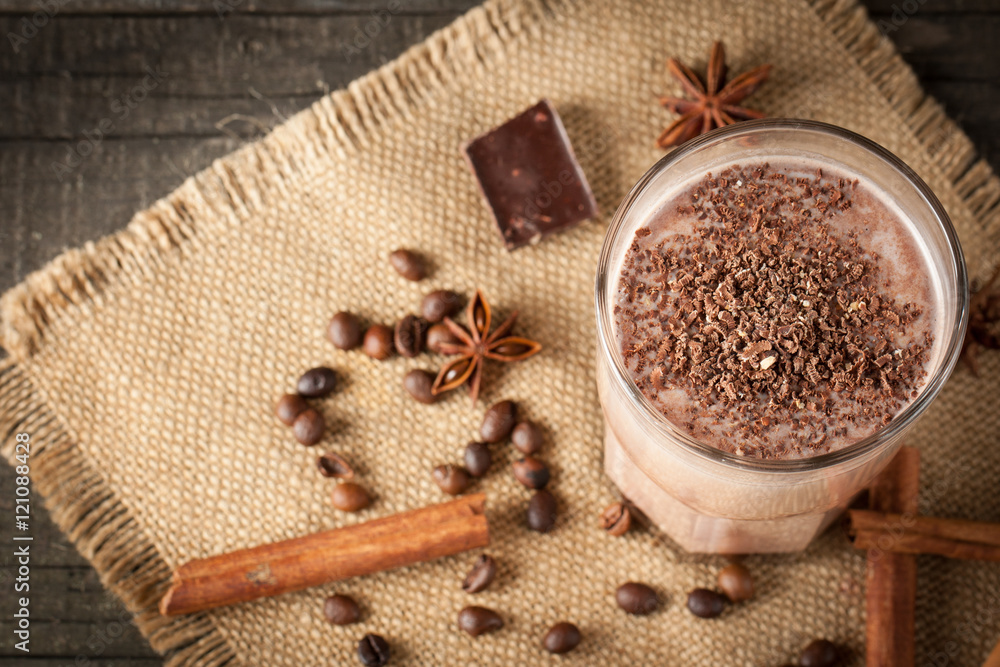 Photo of fresh Made Chocolate Banana Smoothie on a wooden table with coffee and spices. Selective focus. Milkshake. Protein diet. Healthy food concept. Drink, coffee beans, chocolate, Photo of fresh Made Chocolate Banana Smoothie on a wooden table with coffee and spices. Selective focus. Milkshake. Protein diet. Healthy food concept. Drink, coffee beans, chocolate,