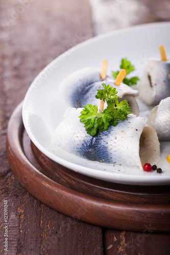 Obraz na plátně Rollmops (rolled marinated herring) with marinated cucumber, salt, pepper and pa