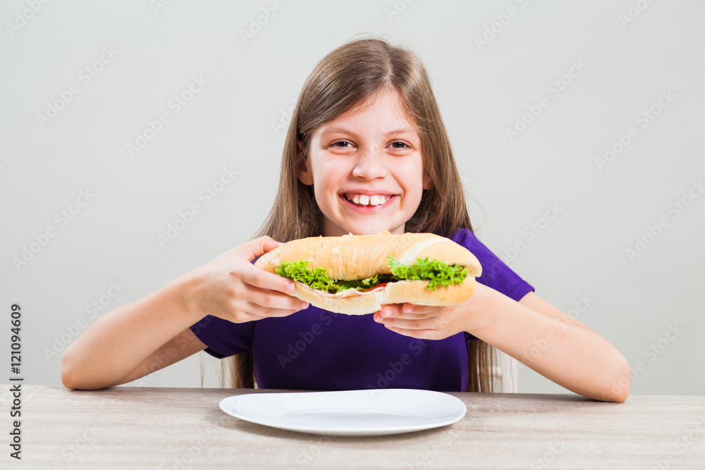 Little girl is happy because she likes to eat sandwich for breakfast. Little girl is happy because she likes to eat sandwich for breakfast.