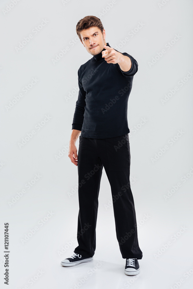 Angry handsome young man standing and pointing on you Angry handsome young man standing and pointing on you