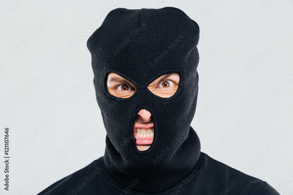 Closeup of angry aggressive young man in balaclava Closeup of angry aggressive young man in balaclava
