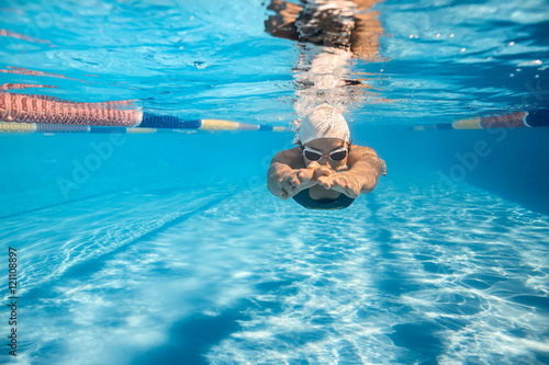 Fototapeta Swimmer in crawl style underwater