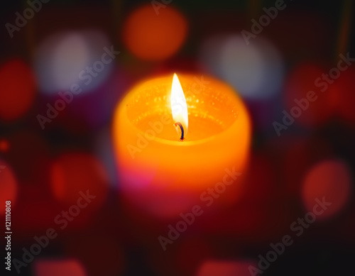 Burning candle on abstract color bacground