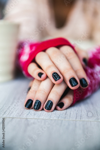 Manicure on female hands with black nail polish