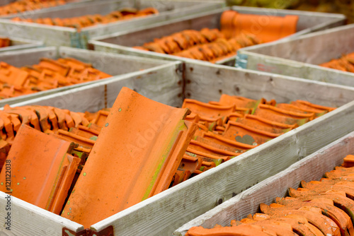 Red roof tiles stored in pallet containers