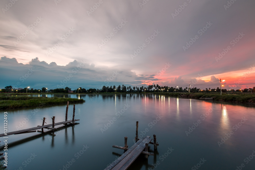Fototapeta premium Wooded bridge in the port at sunset.