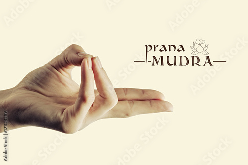 Image of woman hand in prana mudra. Gesture is  isolated on toned background.