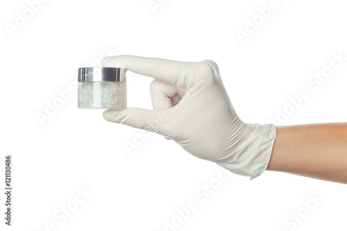 doctor's hand in blue sterilized surgical glove holding medicine