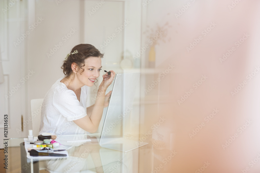 Woman at home applying mascara Woman at home applying mascara