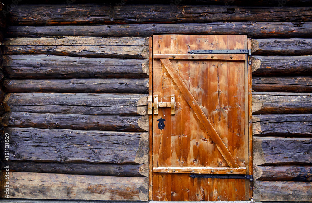 Fototapeta premium Newly made old viking style wood door fastened in wall made of large timber, of building in Telemark, Norway
