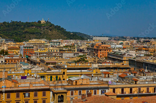 Look over yellow Roman houses at building standing on the hill