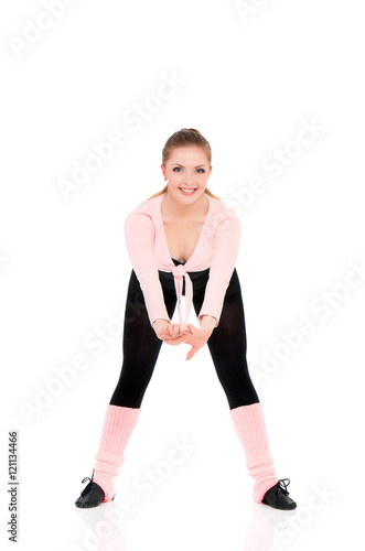 Healthy lifestyle - full length portrait of smiling young fitness girl in perfect shape. Sporty caucasian female model isolated on white background. Cheerful young woman doing stretch exercise.