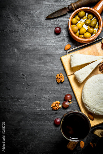 Sheep cheese with red wine , nuts and olives.