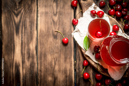 Fresh cherry juice .On wooden background.