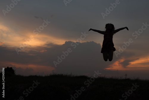 silhouette of woman happy jumping at sunset